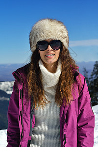 快乐的轻女人冬天的自然景观与新鲜的雪中享受乐趣图片
