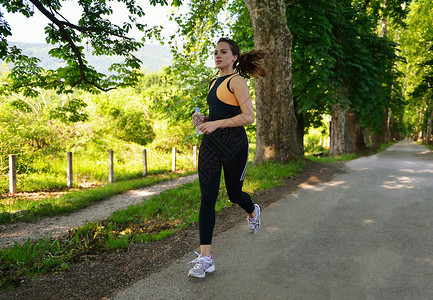 轻漂亮的女人夏季公园慢跑妇女运动户外健康图片