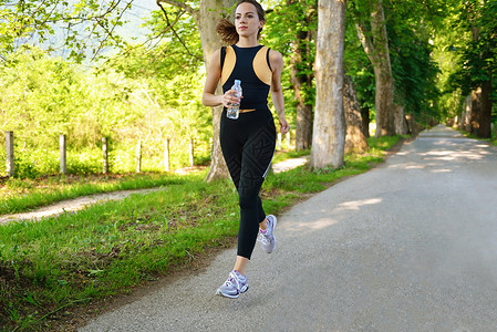 轻漂亮的女人早上公园慢跑妇女运动户外健康图片
