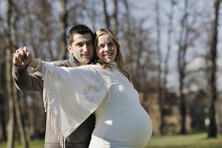 幸福的轻已婚家庭夫妇户外乐趣等待婴儿,并代表轻的家庭成长怀孕的图片