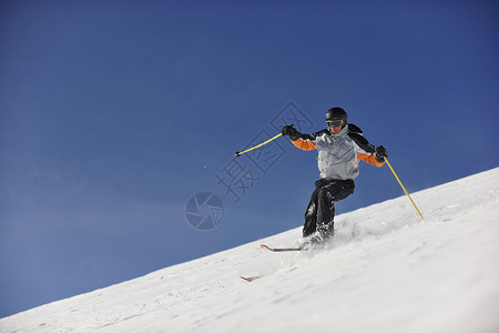 男子滑雪免费骑下山冬季,美丽的晴天粉末雪图片