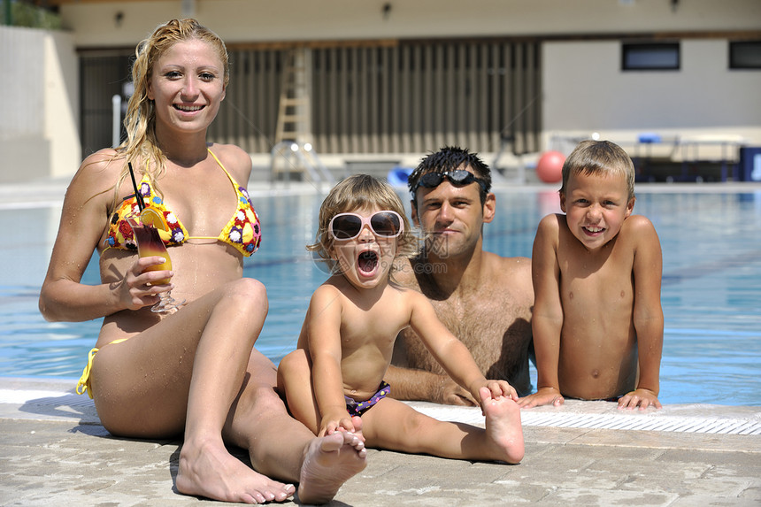 快乐的轻家庭暑假的游泳池里玩得很开心图片