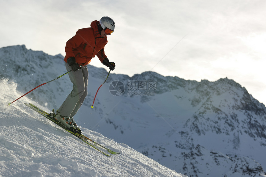 轻的运动员冬季阳光明媚的天,高山坡滑雪运动中玩得很开心图片