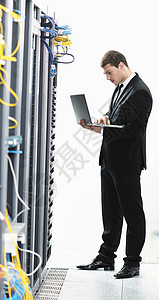 轻的IT工程师商务人员与薄的现代铝笔记本电脑网络服务器机房图片