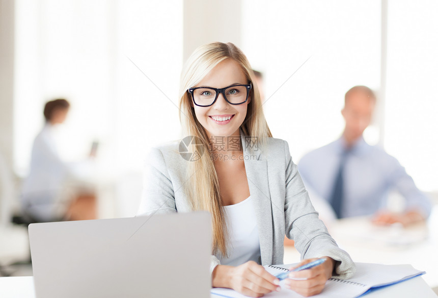 商业微笑的女人,笔记本电脑,文件钢笔办公室图片