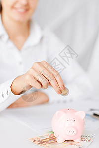 商业,办公室,家庭,学校,税收教育女人手把硬币放进小猪存钱罐图片
