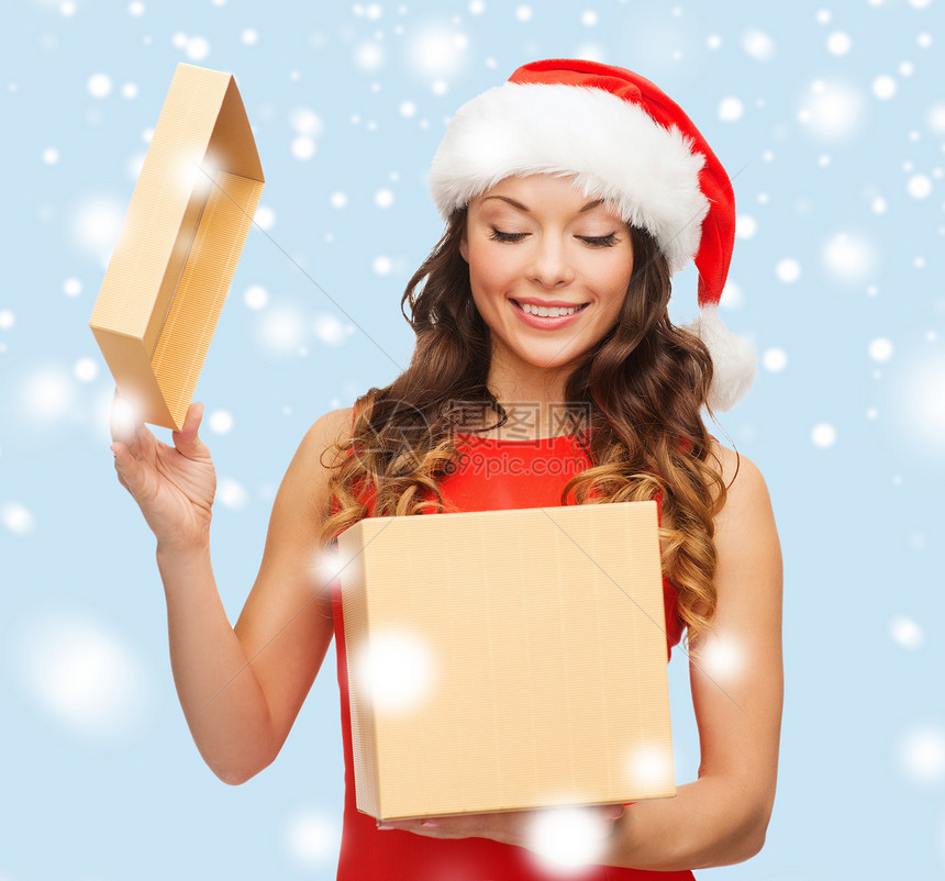 诞节,冬天,幸福的微笑的女人戴着诞老人的帽子礼品盒图片