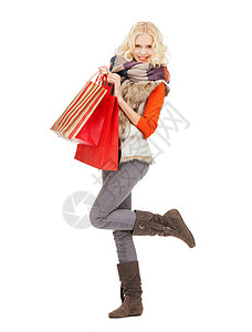 零售销售快乐的少女穿冬天的衣服,带购物袋图片