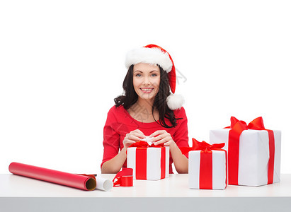 诞节,冬天,幸福的微笑的女人戴着诞老人的帽子,带着许多礼品盒包装纸图片