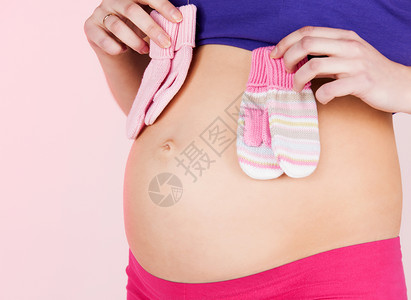 怀孕生育健康孕妇的腹部两婴儿手套高清图片