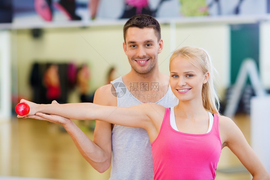健身,运动,训练,健身房生活方式的男教练与女与哑铃锻炼图片