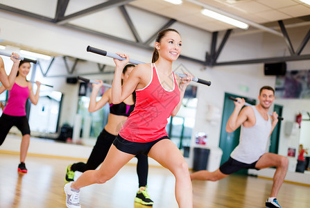 健身,运动,训练,健身房生活方式的群微笑的人健身房里用杠铃锻炼图片