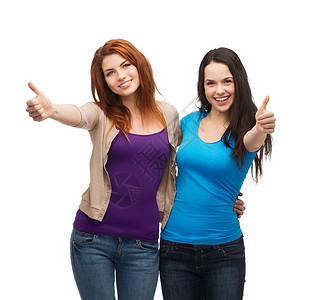 友谊快乐的人的两个微笑的女孩竖大拇指图片
