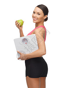 带苹果体重秤的运动女人的照片图片