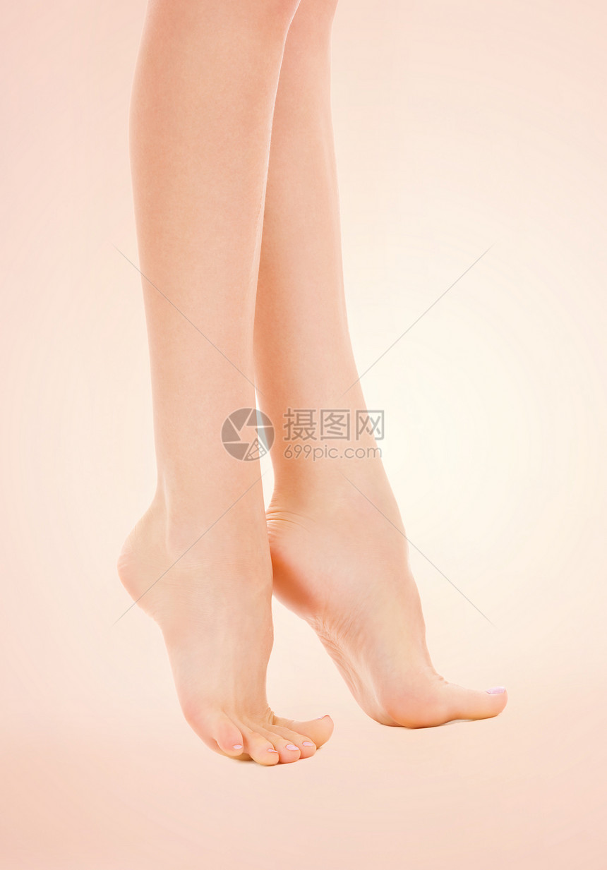 米色背景下苗条女腿的照片图片