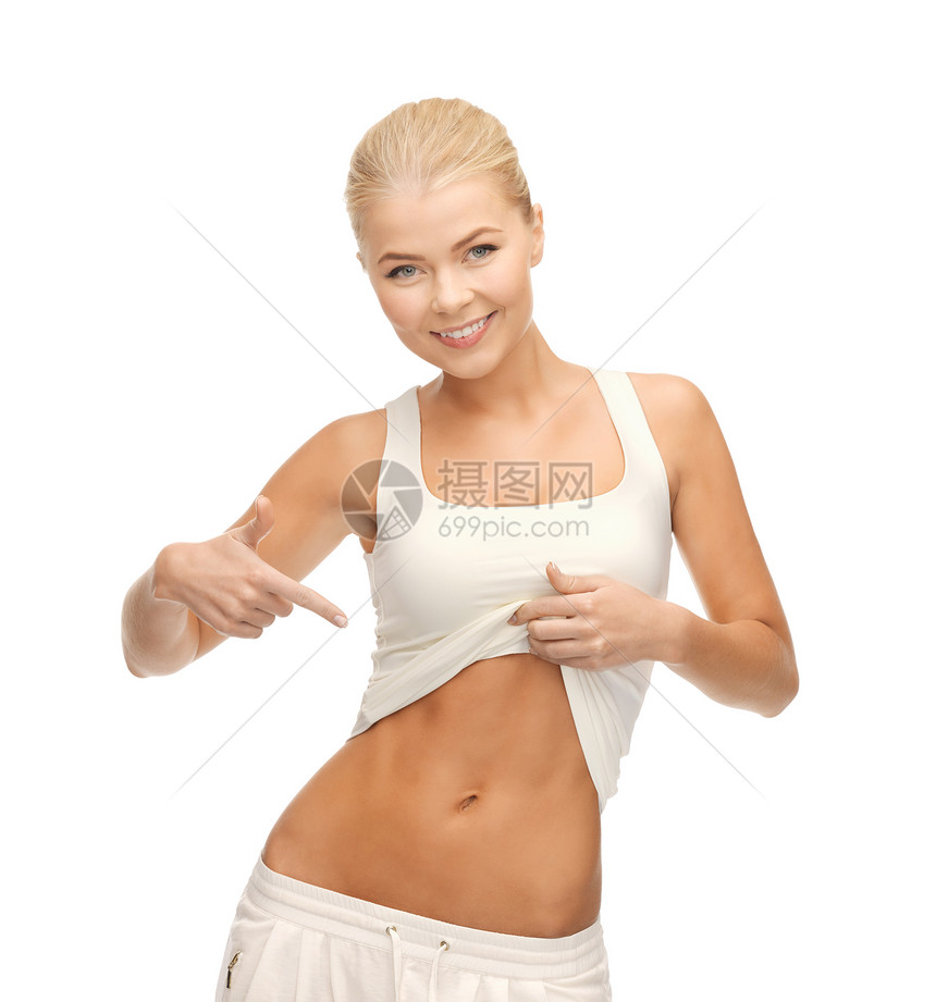 美丽的运动女人指着她的腹肌的照片图片