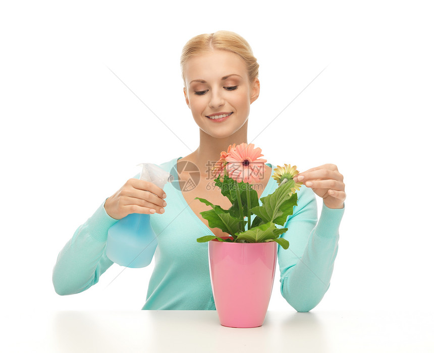 轻的女人着花盆喷雾瓶图片