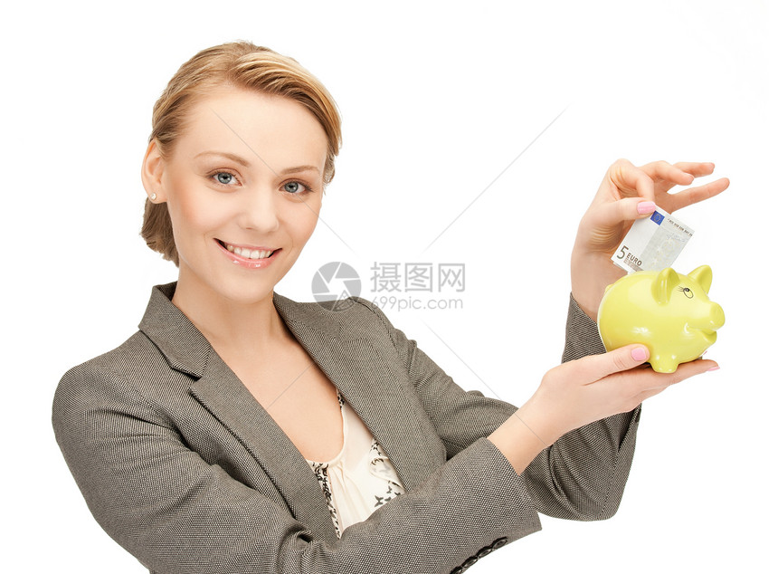 快乐的女商人把现金钱放进小猪存钱罐里图片