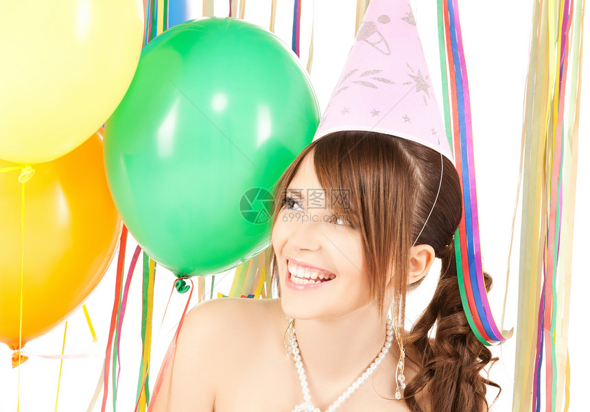 快乐的女孩戴着五颜六色的气球派帽里图片