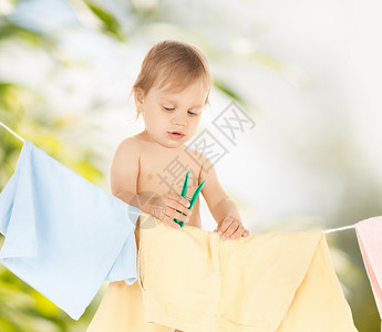 照顾悬挂可爱的婴儿洗衣服的明亮照片背景