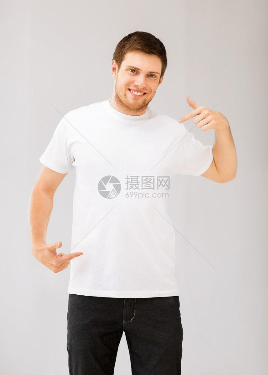 微笑的男人指着空白的白色t恤的照片图片