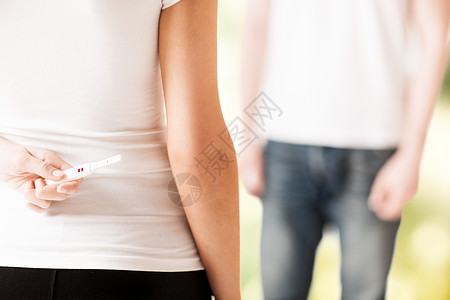 靠近女人的手,向男人隐瞒怀孕测试背景图片