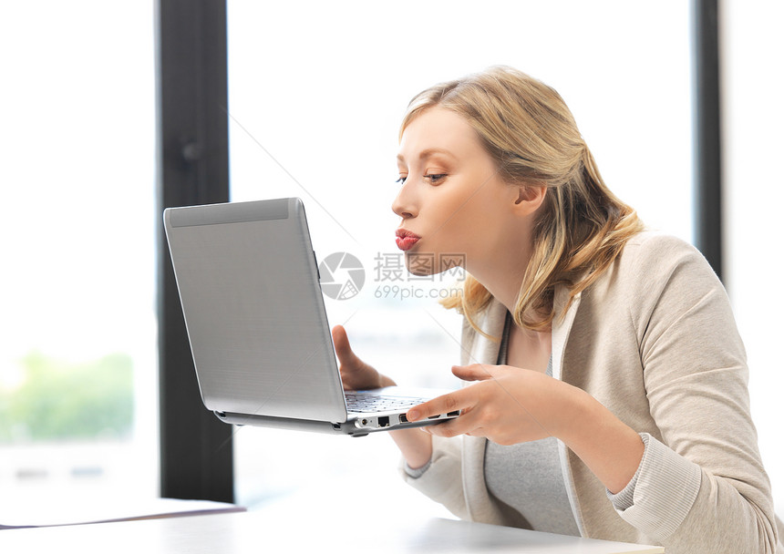 带笔记本电脑的女人亲吻屏幕的照片图片