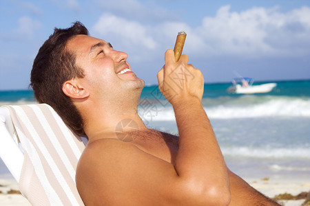 海滩上着雪茄的放松男人的照片图片