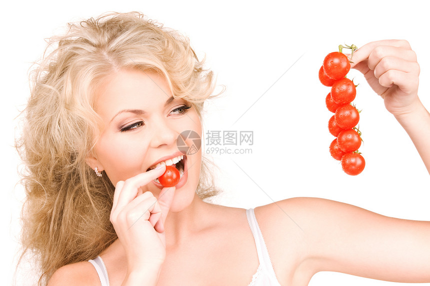 轻美丽的女人成熟的西红柿的照片图片