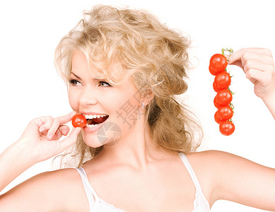 轻美丽的女人成熟的西红柿的照片图片