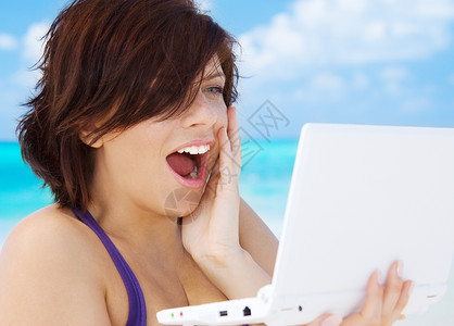 海滩上笔记本电脑的可爱女人背景图片