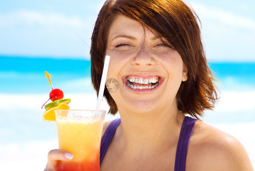 快乐的女人海滩上喝着五颜六色的鸡尾酒图片