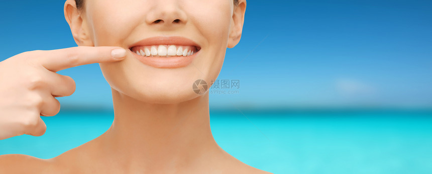 美丽牙齿健康的特写图片,美丽的女人指着她的牙齿图片