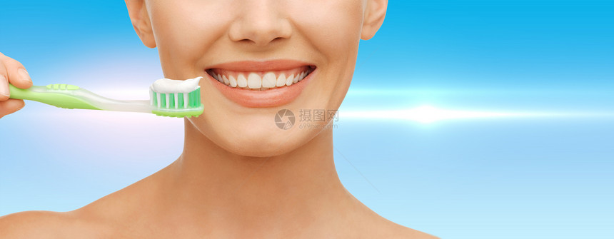 美容牙科健康美丽的女人带绿色牙刷图片