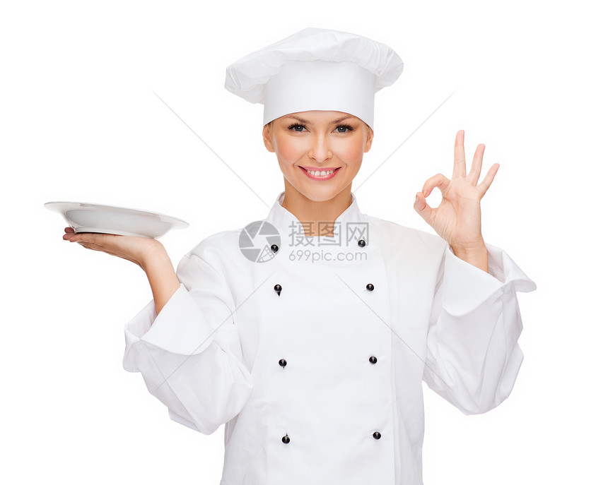 烹饪食物微笑的女厨师,厨师包师与空盘OK标志图片