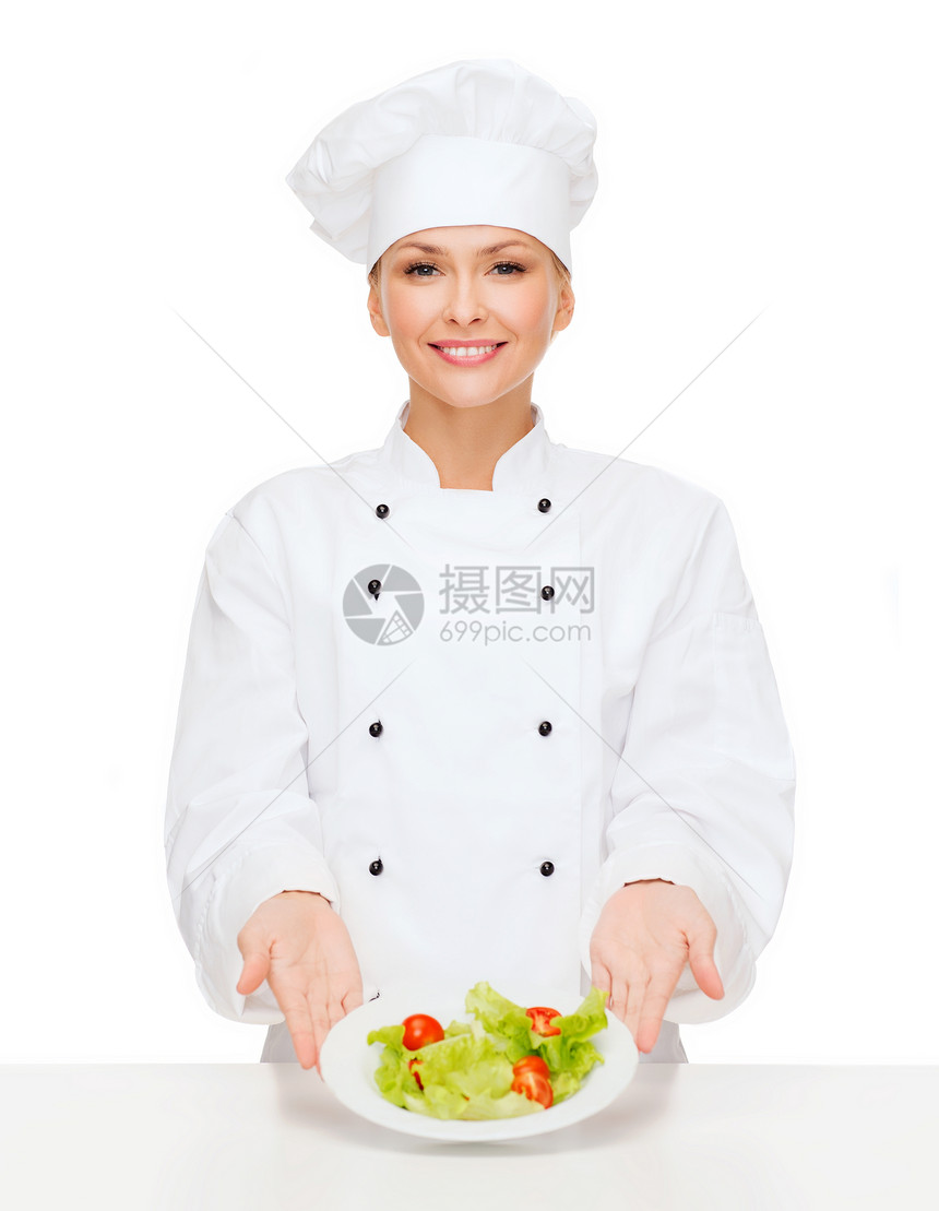 烹饪食物微笑的女厨师,厨师包师与沙拉盘子里图片