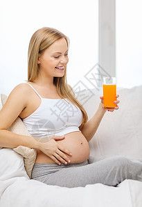 怀孕,母,保健,食物幸福的快乐的孕妇坐沙发上喝新鲜橙汁图片