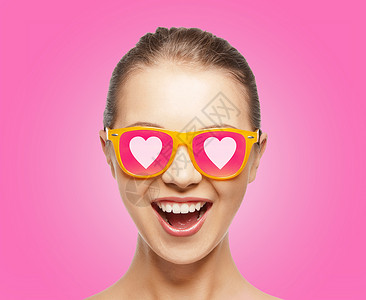 爱,幸福情人节惊讶的少女戴着太阳镜,心粉红色的背景背景图片
