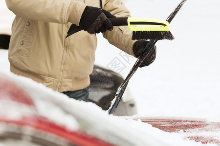 运输,冬季车辆特写的人清理雪汽车挡风璃与刷子背景图片