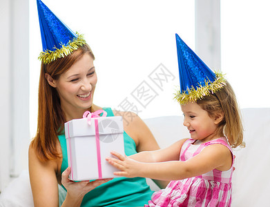 家庭,孩子,庆祝,节日,生日快乐的人的快乐的母亲女儿戴着蓝色的派帽礼品盒背景图片