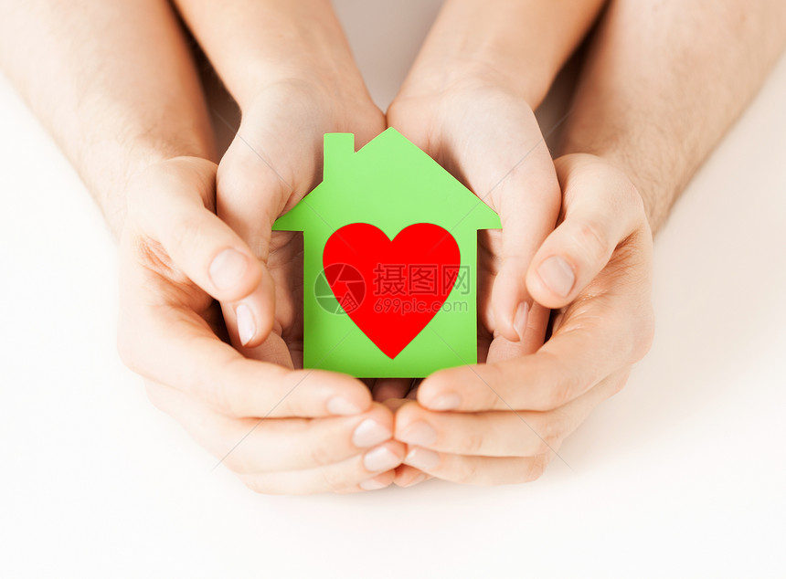 慈善房地产家庭住宅男女手捧红心绿色纸屋的特写照片图片