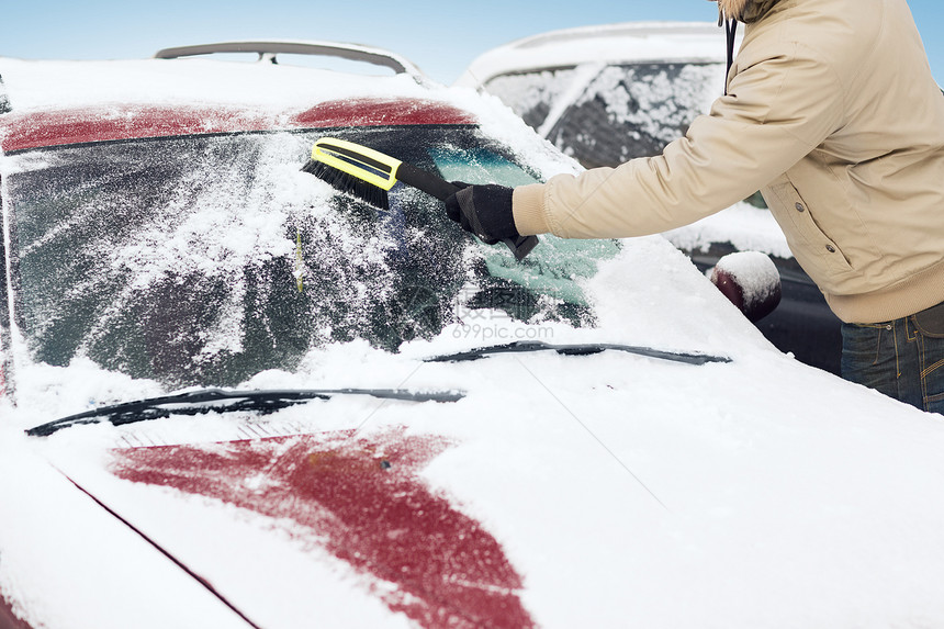 运输,冬季车辆特写的人清理雪汽车挡风璃与刷子图片