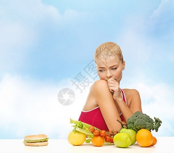 健身,饮食,健康食物的怀疑妇女与水果汉堡包图片