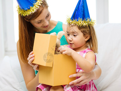 家庭,孩子,庆祝,节日,生日快乐的人的快乐的母亲女儿戴着蓝色的帽子礼品盒图片