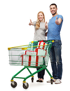 幸福,假期,购物夫妇的微笑的夫妇与购物车礼品盒其中竖大拇指图片