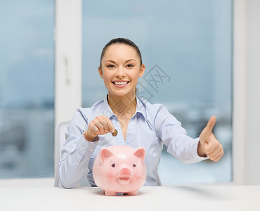 银行金融可爱的女人,带着储蓄罐现金,竖大拇指图片
