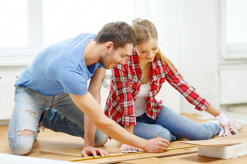 修理,建筑家庭微笑夫妇测量木地板图片