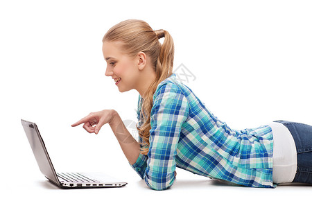 幸福,技术,互联网人的微笑的轻女人躺地板上,用笔记本电脑手指图片