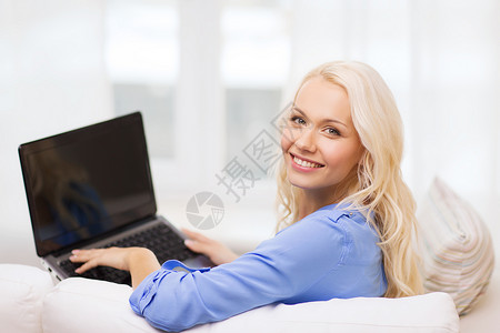 家庭,技术互联网微笑的女人坐沙发上,家里笔记本电脑图片