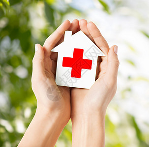 红十字救援医疗保健医药慈善理念双手着带红十字标志的白纸屋背景